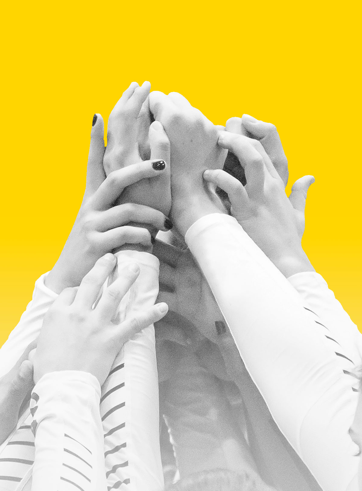 Group of students holding hands up in unison.