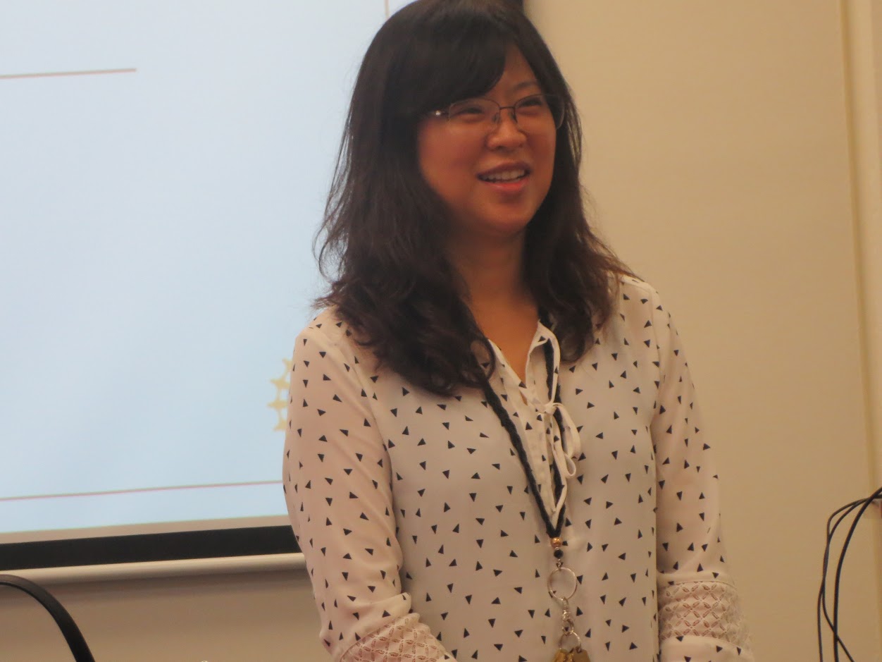 Dr. Elaine Kang in front of a projector screen