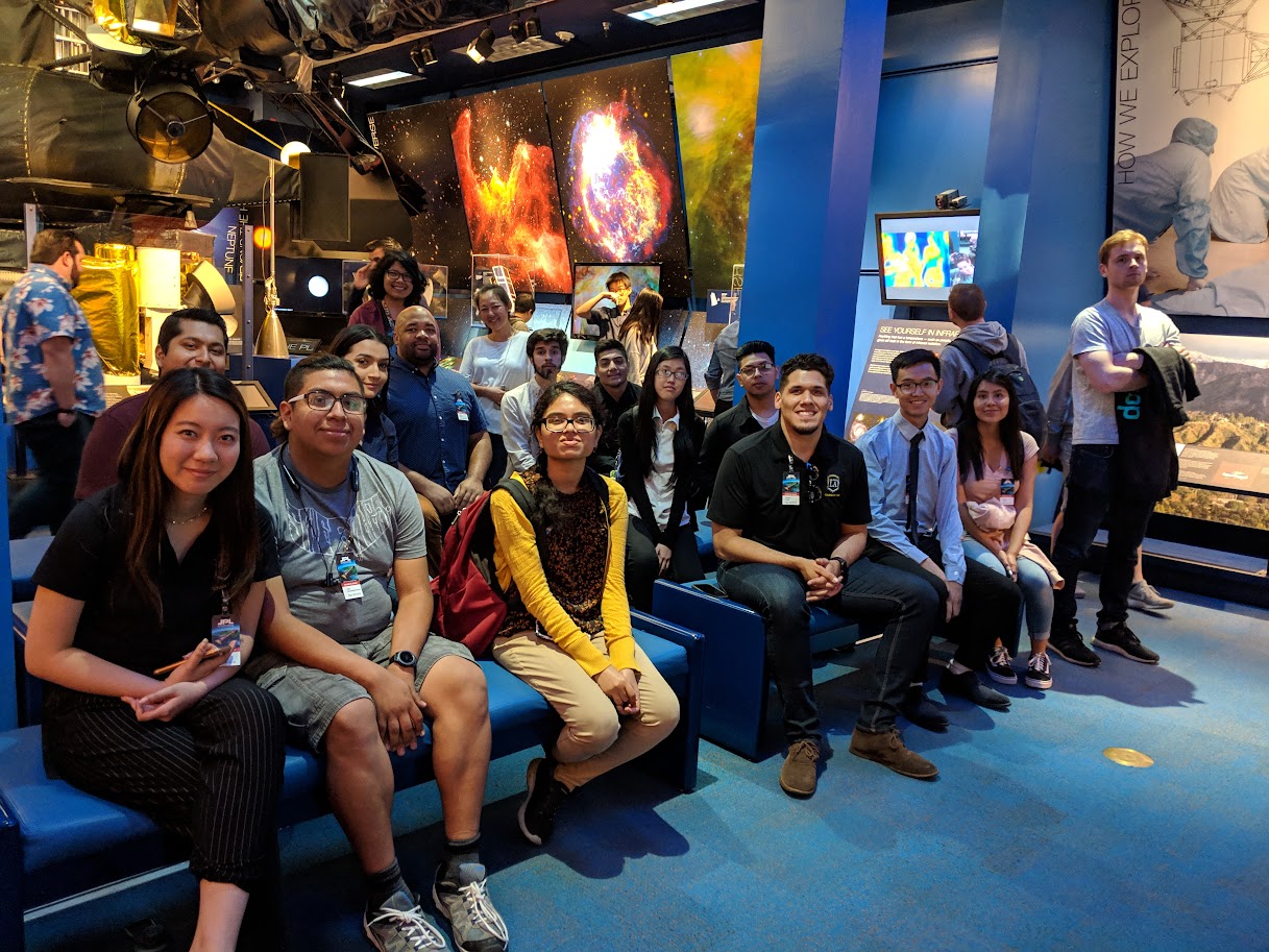 CAPS members in front of an outer space display at JPL