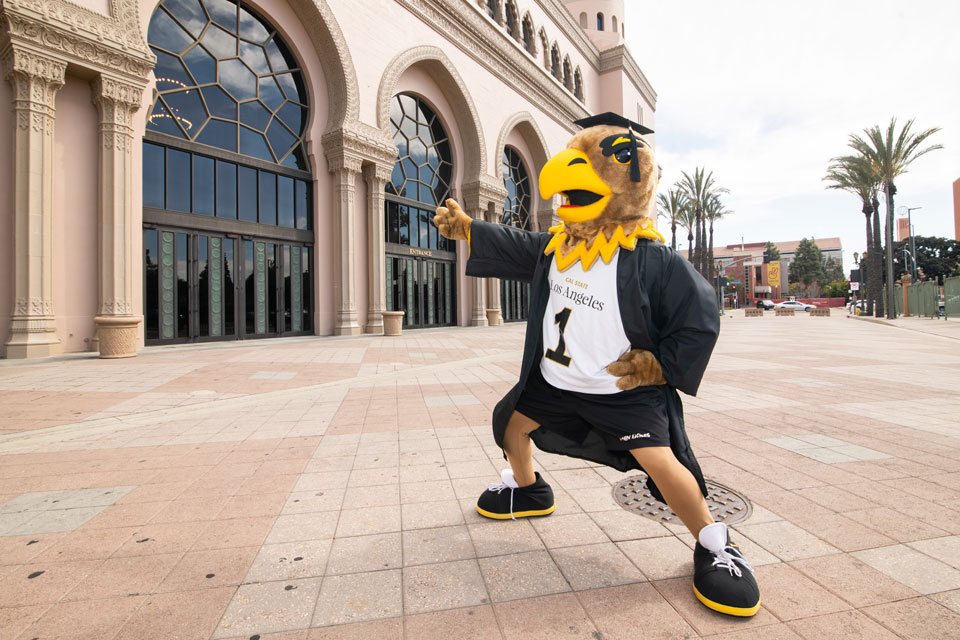 A suited mascot in front of a building.