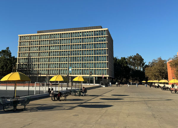A wide angle view of a plaza with buildings and trees.