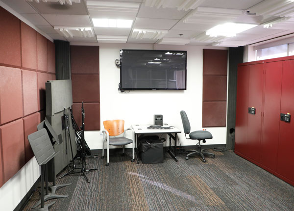 A room with a computer and recording equipment in it.