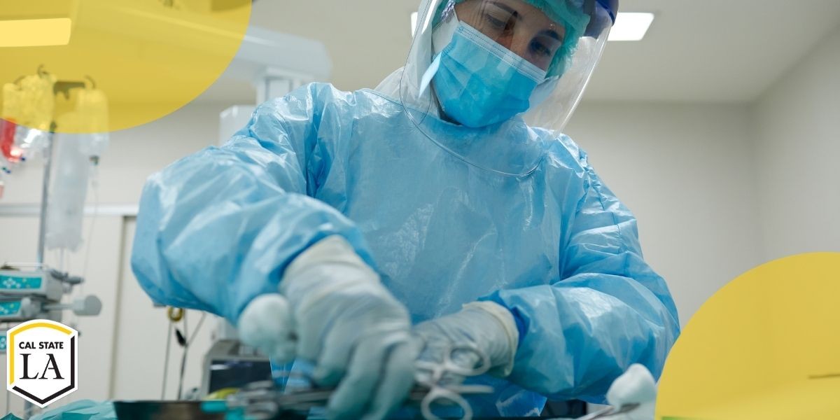 Female in bluw scrubs and mask holding surgical instruments