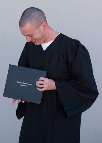 Inmate holding diploma on graduation day